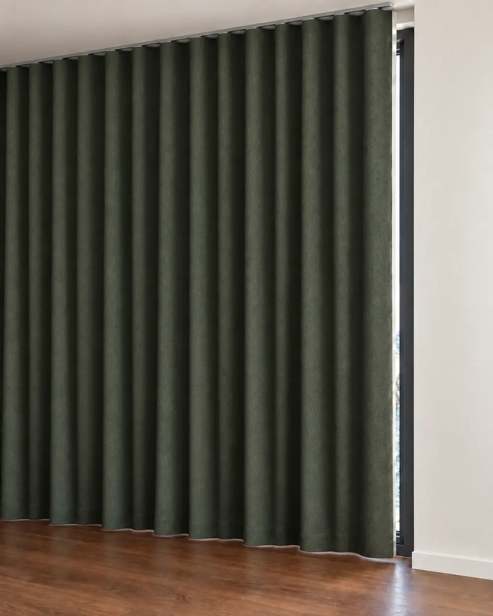 Dark blackout curtain in wave folds with a narrow strip of light at the edge