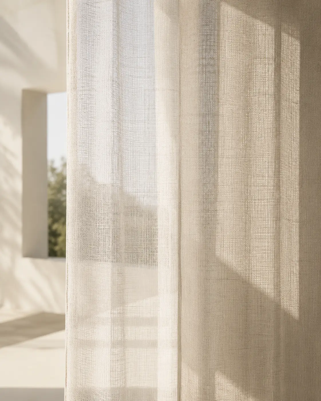 Play of shadow through sheer textile on a limewashed wall