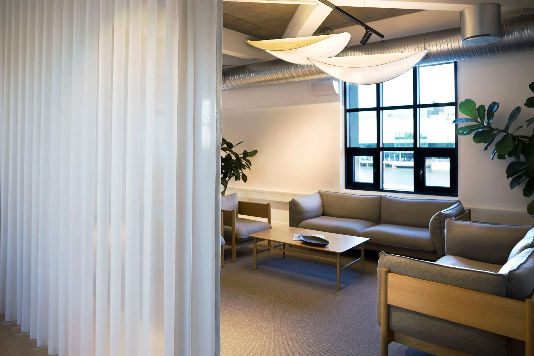 Lounge area in the Copenhagen headquarters with a transparent curtain in the foreground
