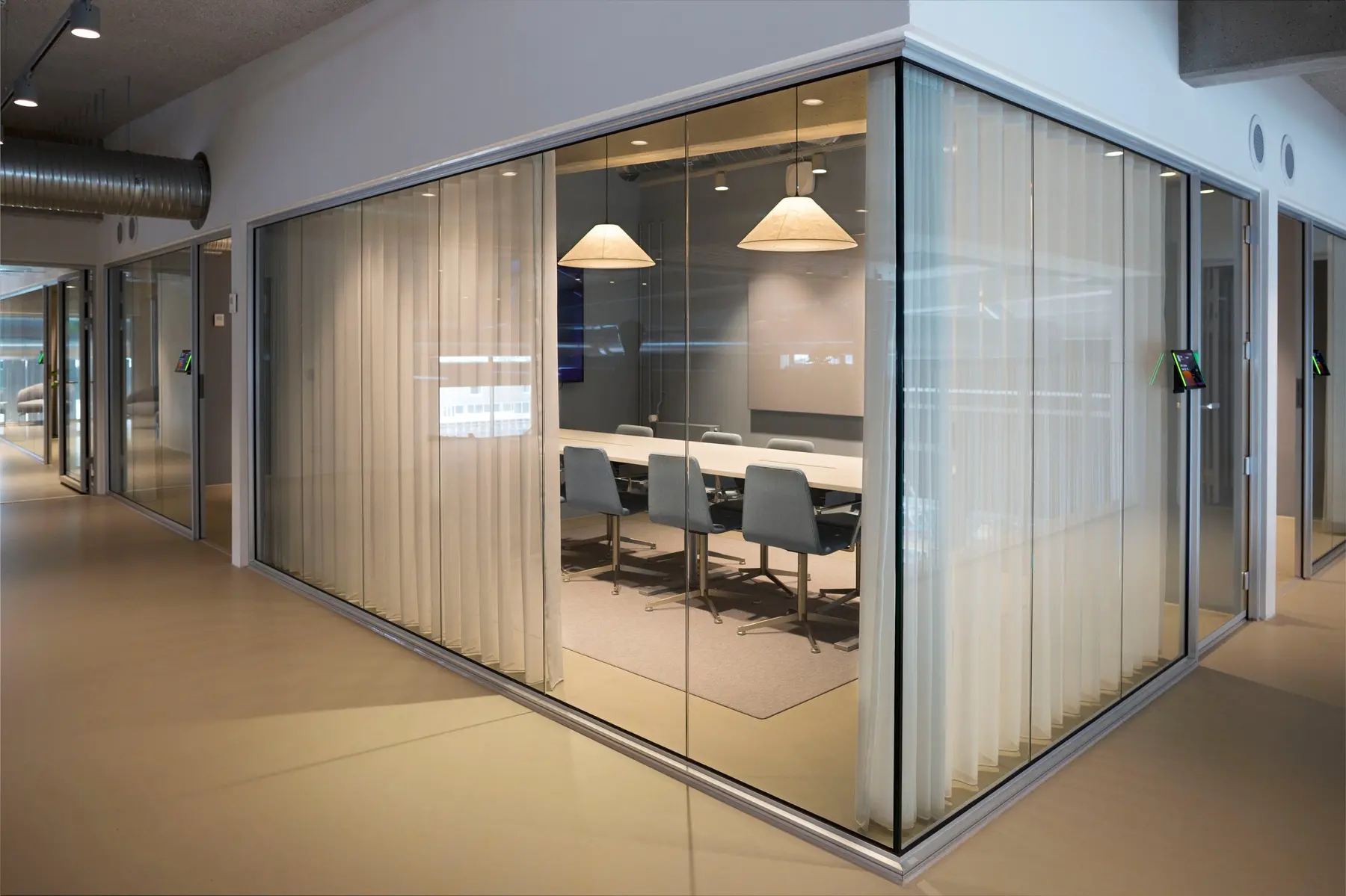 Glazed meeting room framed by light curtains in Nordhavn